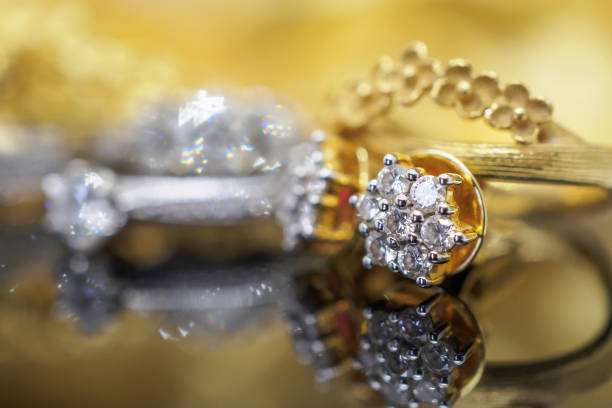 istock Luxury gold Jewelry diamond earrings with reflection on black background 962400430