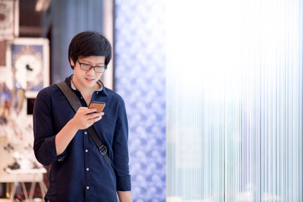 istock Young Asian man using smartphone in department store 962402884