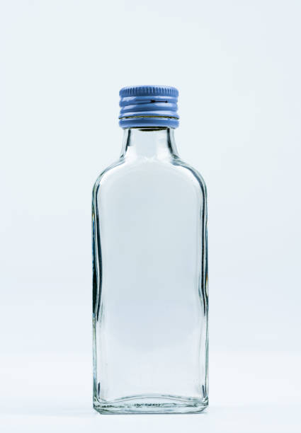 istock Empty transparent glass bottle with closed aluminum cap isolated on white background with blank label and copy space. Use for beverage or medicine product design template. Glass bottle packaging. 962403434