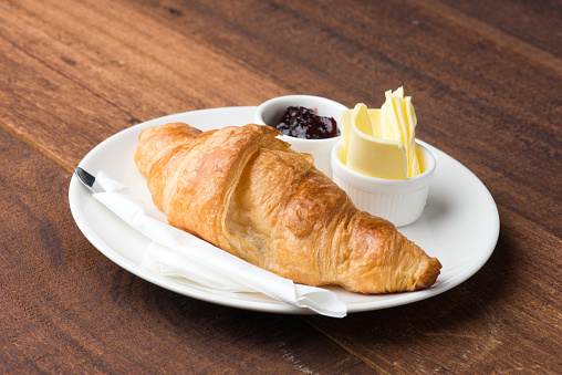 croissant butter and jam with wood background
