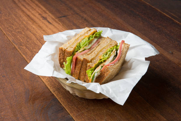 istock ham sandwich with wood background 962407462