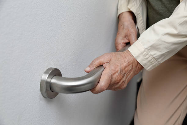istock Elderly woman holding on handrail for safety walk steps 962408744