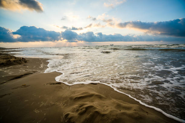 Amazing spectacular wash washing up on sandy beach Padre Island Beach sunrise reflections stock photo