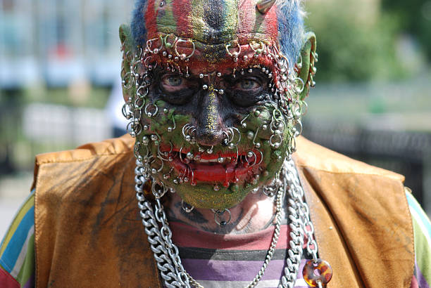 Man's face covered in piercings and face paint Heavily pierced and decorated eccentric Pierced stock pictures, royalty-free photos & images