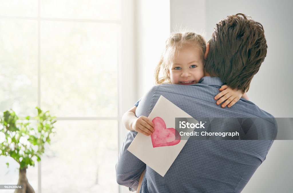 daughter congratulating dad Happy father's day! Child daughter congratulating dad and giving him postcard. Daddy and girl smiling and hugging. Family holiday and togetherness. Father Stock Photo