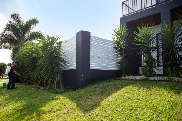 Beautiful white vinyl fence in back yard with nice landscaping in the foreground and background