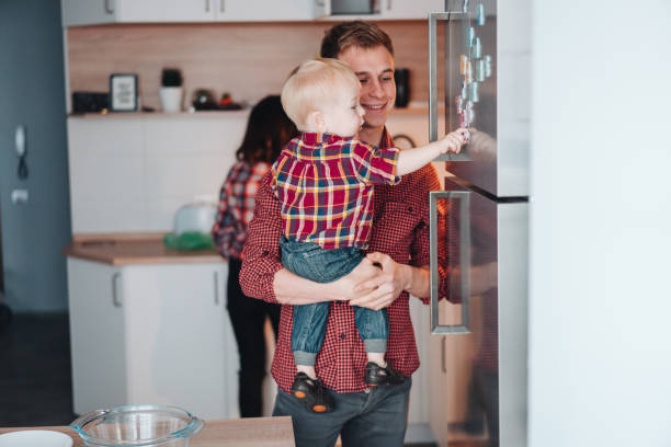 istock Dad and little son in the kitchen by the fridge 962421744