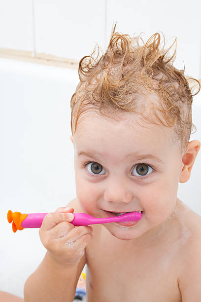 Baby girl brushing her teeth stock photo