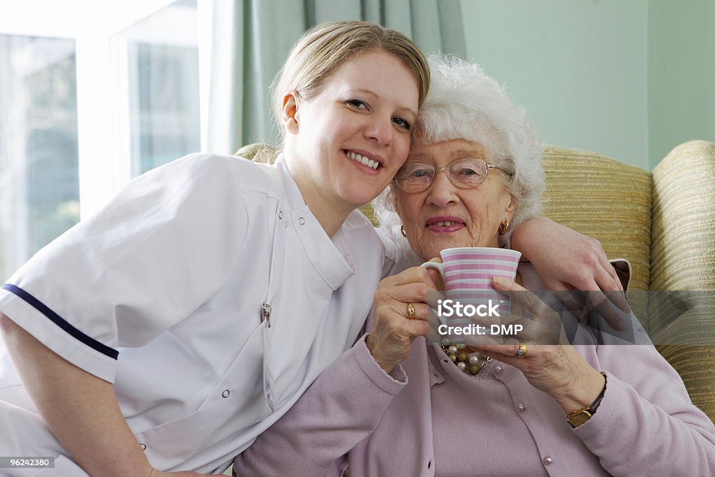 young Nurse and senior woman cuddling in a care home  80-89 Years Stock Photo