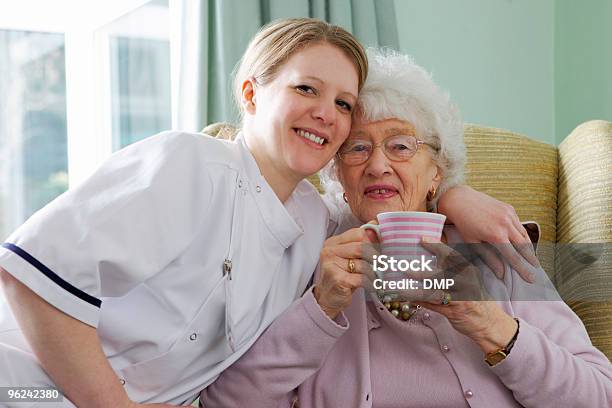 Young Nurse And Senior Woman Cuddling In A Care Home Stock Photo - Download Image Now