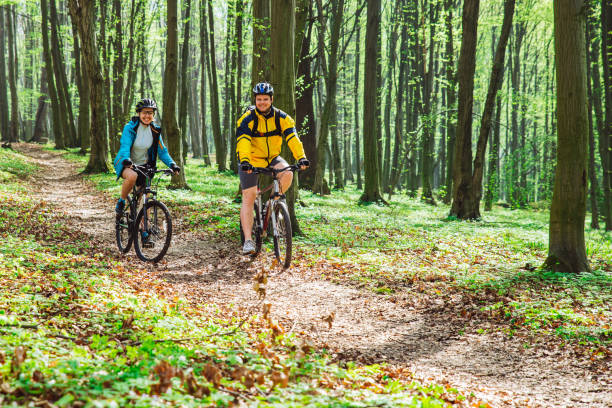 istock couple riding bicycle in forest in warm day 962431530