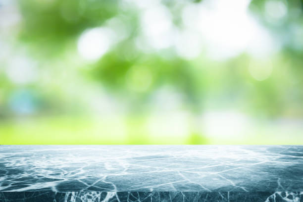 istock Gray marble stone counter top or table on backdrop blurred nature background / for display or montage your products / empty grey marble background concept. 962436640
