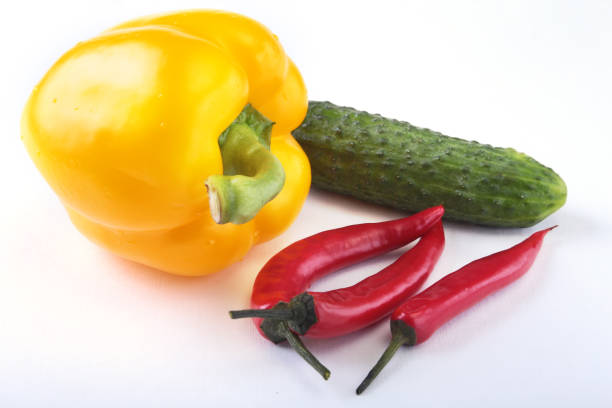 Assorted vegetables, fresh bell pepper, chilli pepper and cucumber isolated on white background. Selective focus