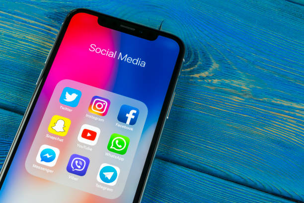 apple iphone x sulla scrivania dell'ufficio con icone dei social media facebook, instagram, twitter, applicazione snapchat sullo schermo. social network. avvio dell'app di social media. - filtro automatico di post produzione foto e immagini stock