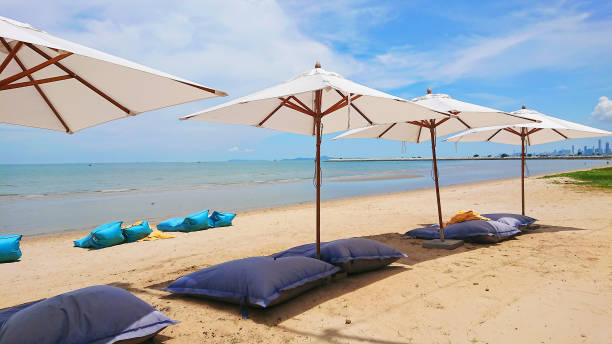 istock Four sleeping chairs with sun umbrella on thr beach. 962442934