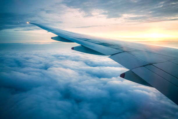 In Flight View of Airplane's Wings on Sunset planes flying overhead stock pictures, royalty-free photos & images