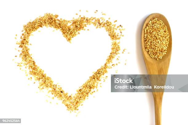 Wooden Spoon With A Long Handle Is Filled With Sesame Seeds Heart Isolated On White The Concept Kitchen Cooking Vegetarianism Healthy Food Stock Photo - Download Image Now