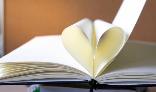 istock close up heart shape from paper book on book stack with copy space background for text. 962452732
