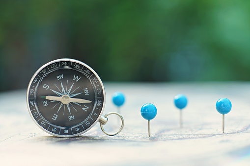 Compass and pin point marking with vintage world map background