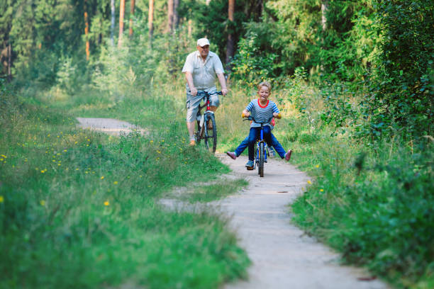 istock active senior with grandkids riding bikes in nature 962454042