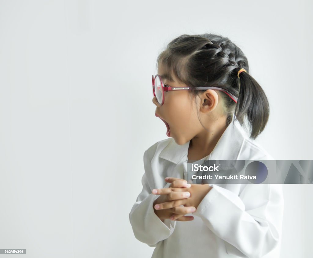 asian girl with big glass and science suite action on white screen asian girl with big glass and science suite action on white screen. Funny  Action kid model with doctor or science costume. Child Stock Photo