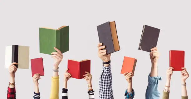 The hands of people hold books