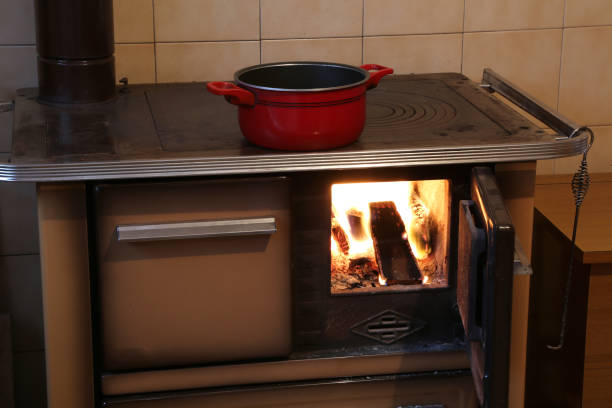 red pot over the old wood-burning stove in the kitchen red pot over the old wood-burning stove in the kitchen of a chalet back boiler wood burner stock pictures, royalty-free photos & images