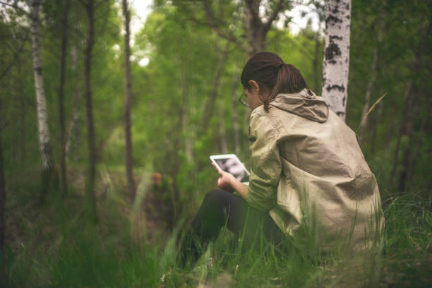 istock Young woman uses tablet outdoors 962464322