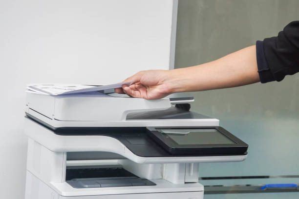 istock close up man put paper on printer for scanning and copying in office 962464352