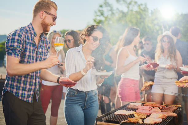 istock Group of people standing around grill. 962466358