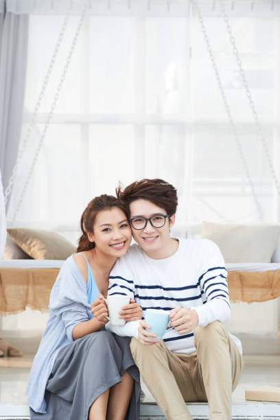 istock Cheerful young Asian couple enjoying coffee 962467328