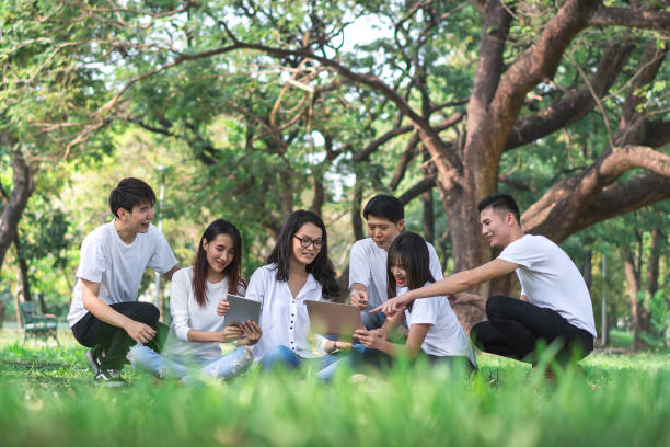 istock Six students are making group reports to send instructors. People meeting team in the park outdoors. Concept of education, together, teamwork, learning, information, knowledge and research. 962471294