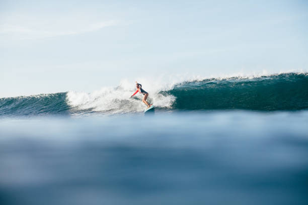 istock young woman in wetsuit surfing on ocean wave 962473006