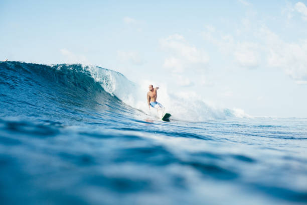 istock shirtless young man surfing on sunny day 962475296