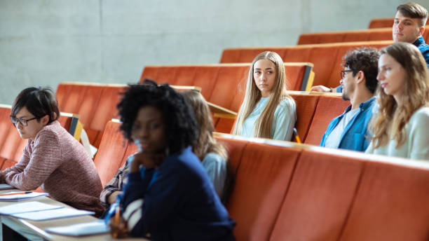 istock In the University Lecture Hall Multi Ethnic Group of Students Waiting For Teacher. Auditorium Full of Smart Young People with Bright Future Before Them. 962475482