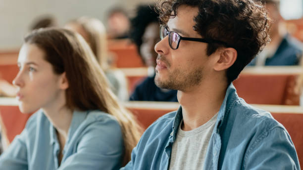 istock Attentive Hispanic Student Listening to a Lecture in a Classroom. Young People Study at the University. 962475758