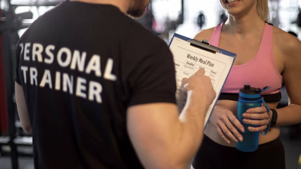 istock Personal trainer discussing weekly meal plan with female client in gym, support 962476716