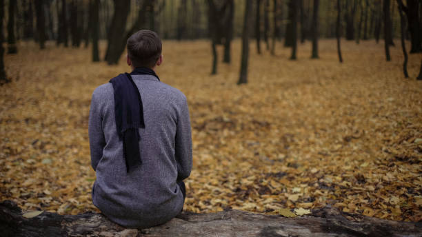 istock Man sitting in park alone, gray tones express depression, sadness, melancholy 962477652