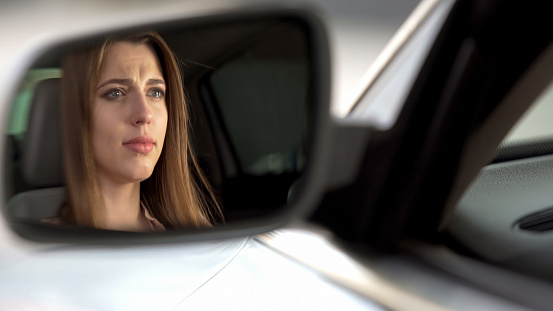 Beautiful upset woman sitting in automobile and crying, break-up and sadness