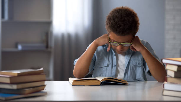 istock Focused boy learning literature, reading book in library, preparing for exam 962478066