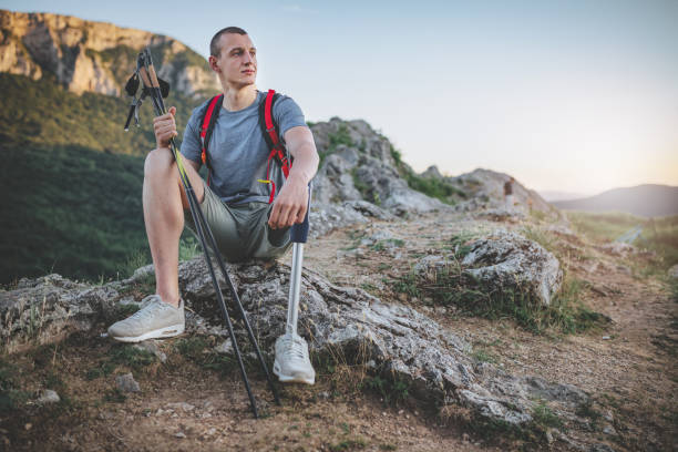 Hiker with artificial limb on top of the mountain Man with an artificial leg hiking the mountains, living the healthy lifestyle. disabled person hiking outdoors stock pictures, royalty-free photos & images