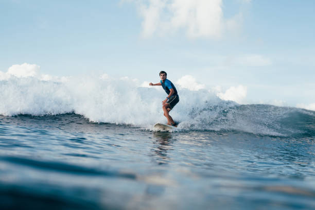 istock handsome young man in wetsuit surfing on sunny day 962478612