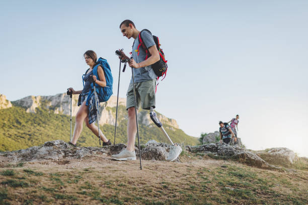 Together we can do anything A group of people hiking the mountains, living the healthy lifestyle, with an amputee friend. disabled person hiking outdoors stock pictures, royalty-free photos & images