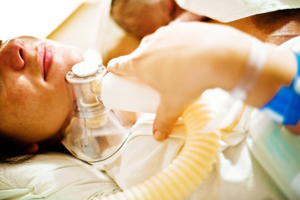 Mother Lying In Hospital Bed - In Labour Pain And In Discomfort. Using Nitrous Oxide stock photo