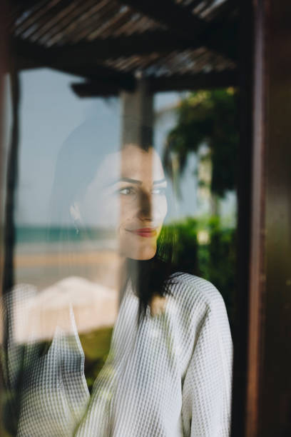 istock Woman looking out her hotel room window 962482576