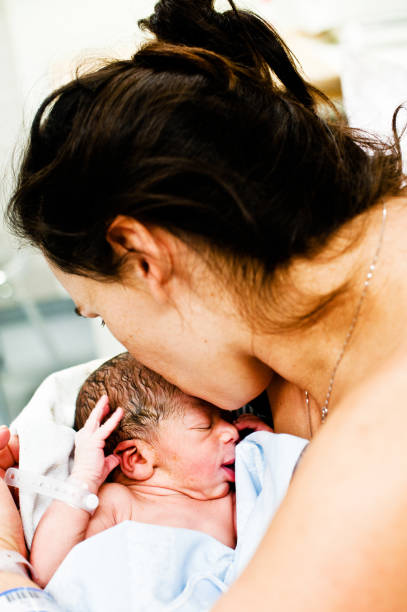 istock Maternal Bond: Mother Kisses Child (New-born Baby) On Forehead 962484738