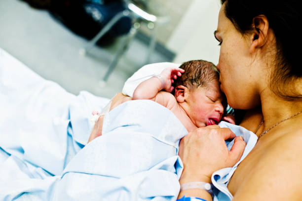 istock Maternal Bond: Mother Kisses Child (New-born Baby) On Forehead 962484776