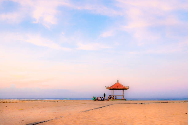 Palm trees on white sandy beach, two sunbed and parasol. View of nice tropical beach