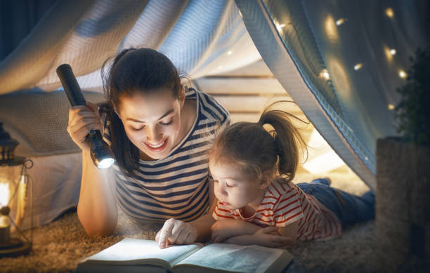 istock Mom and child reading book 962487200