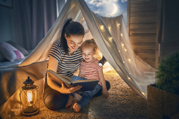 istock Mom and child reading book 962487230